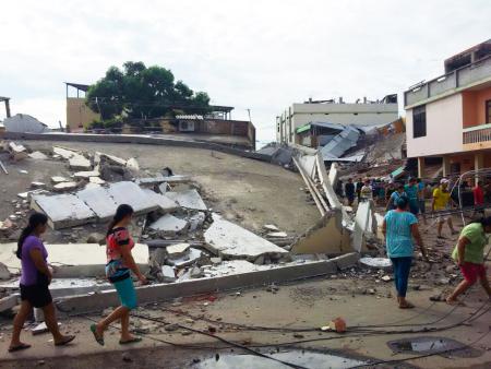 Mujeres caminan entre los edificios destruidos por el terremoto en la ciudad de Manta, Ecuador