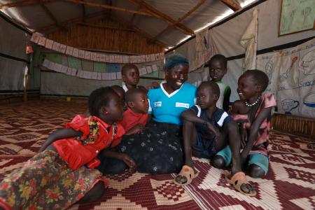 Halima con algunos de los niños y niñas a los que cuida en el centro de Cuidado y Desarrollo de la Primera Infancia de Plan International