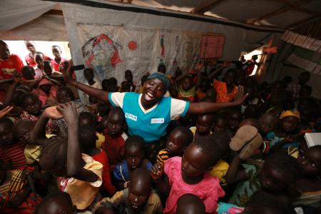 Halima con algunos de los niños y niñas a los que cuida en el centro de Cuidado y Desarrollo de la Primera Infancia de Plan International