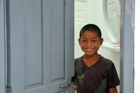 Un niño de Laos sonríe en el baño del colegio Un niño de Laos sonríe en el baño del colegio