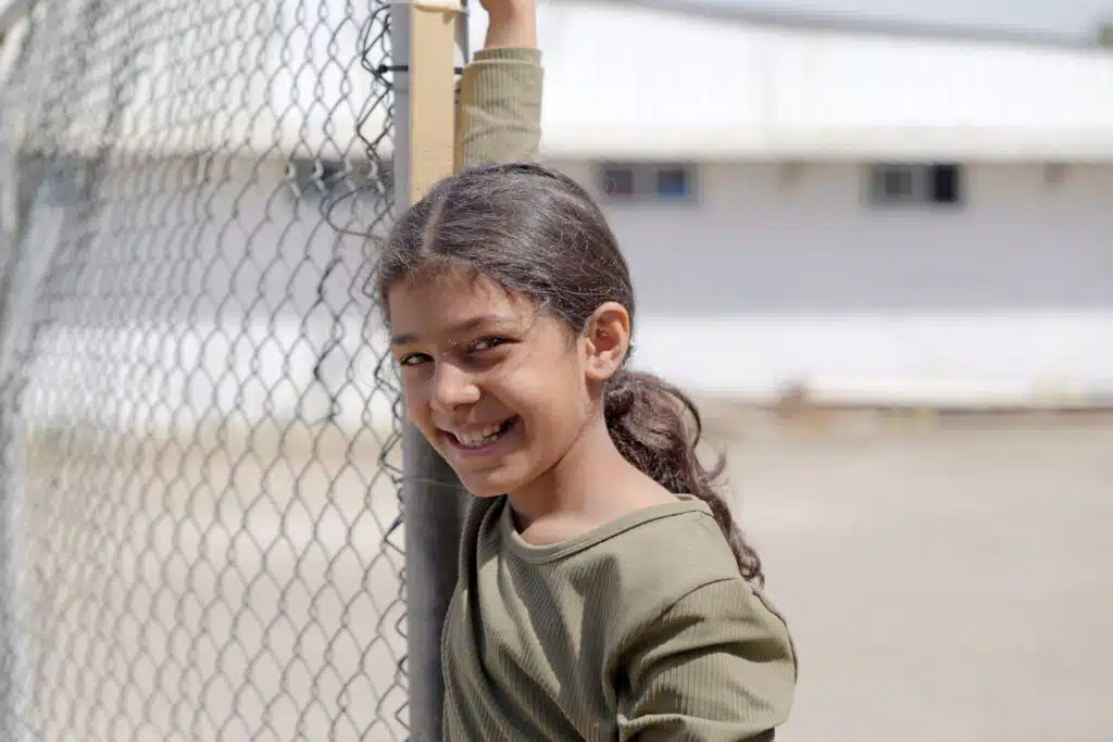 Laila, de ocho años, posa sonriente en uno de los centros para desplazados internos en el Líbano © Plan International / Hasan Noureddine