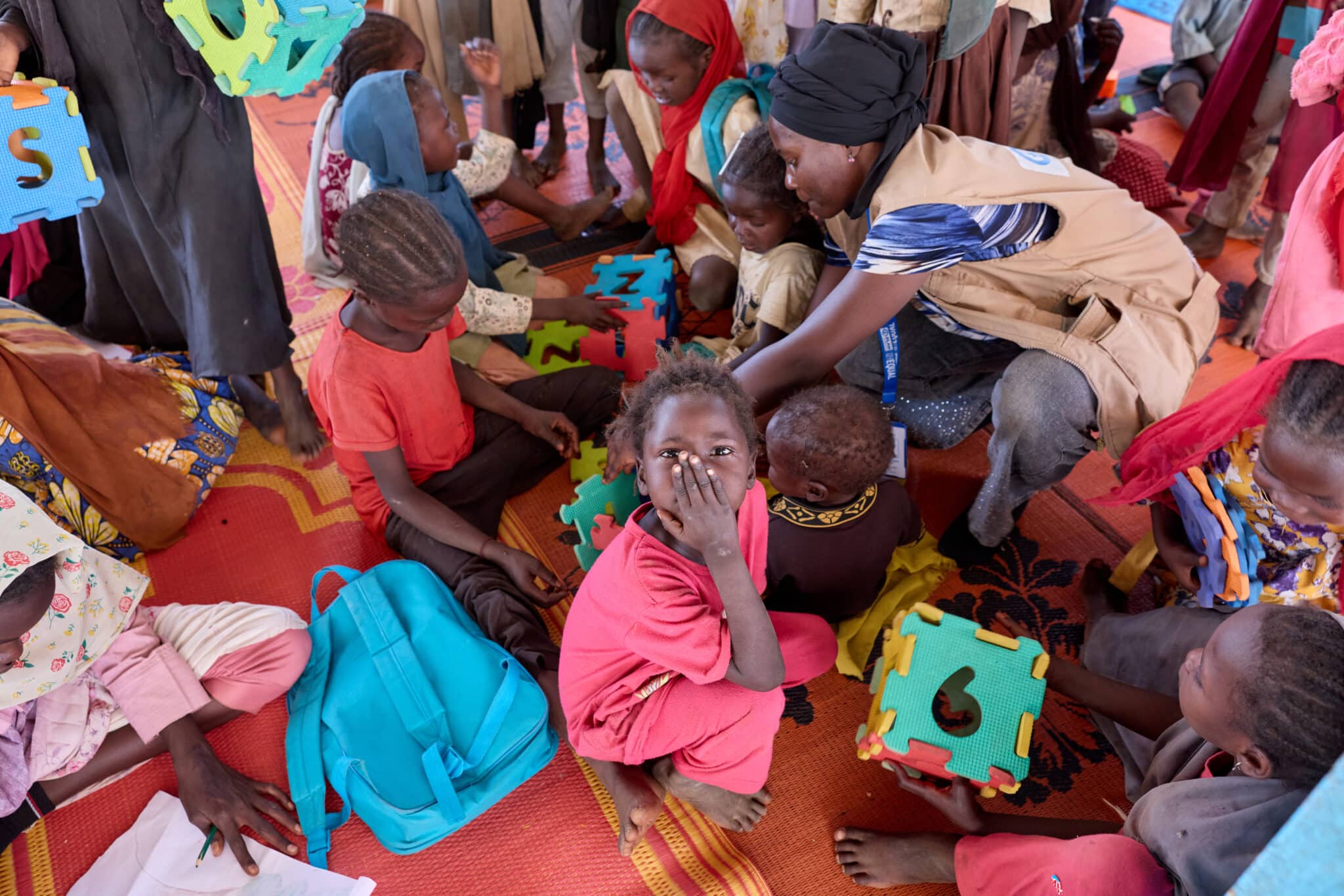 Niños y niñas juegan en uno de los espacios amigables para la infancia construidos por Plan International para ofrecer lugares seguros a las personas desplazadas por el conflicto en el campo de Aboutengue © Plan International / Armstrong Too