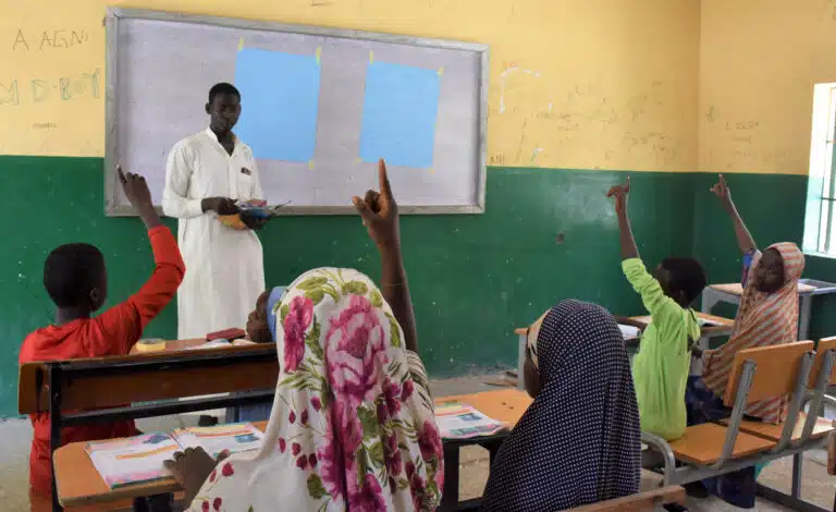 Un profesor da clase en un programa de aprendizaje acelerado impulsado por Plan International en Nigeria para facilitar el regreso a la educación formal a niñas y niños desplazados en los estados de Borno y Yobe. © Plan International